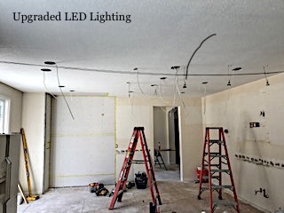 ladders set up to install LED can lights in ceiling